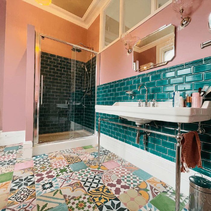 Badezimmer mit Fayrouz Patchwork Feinsteinzeugfliesen im marokkanischen Stil im Format 20 × 20 cm, verlegt als ausdrucksstarker Boden. Die Kombination aus farbenfrohen geometrischen und floralen Mustern erzeugt einen markanten, dekorativen Patchwork-Effekt.