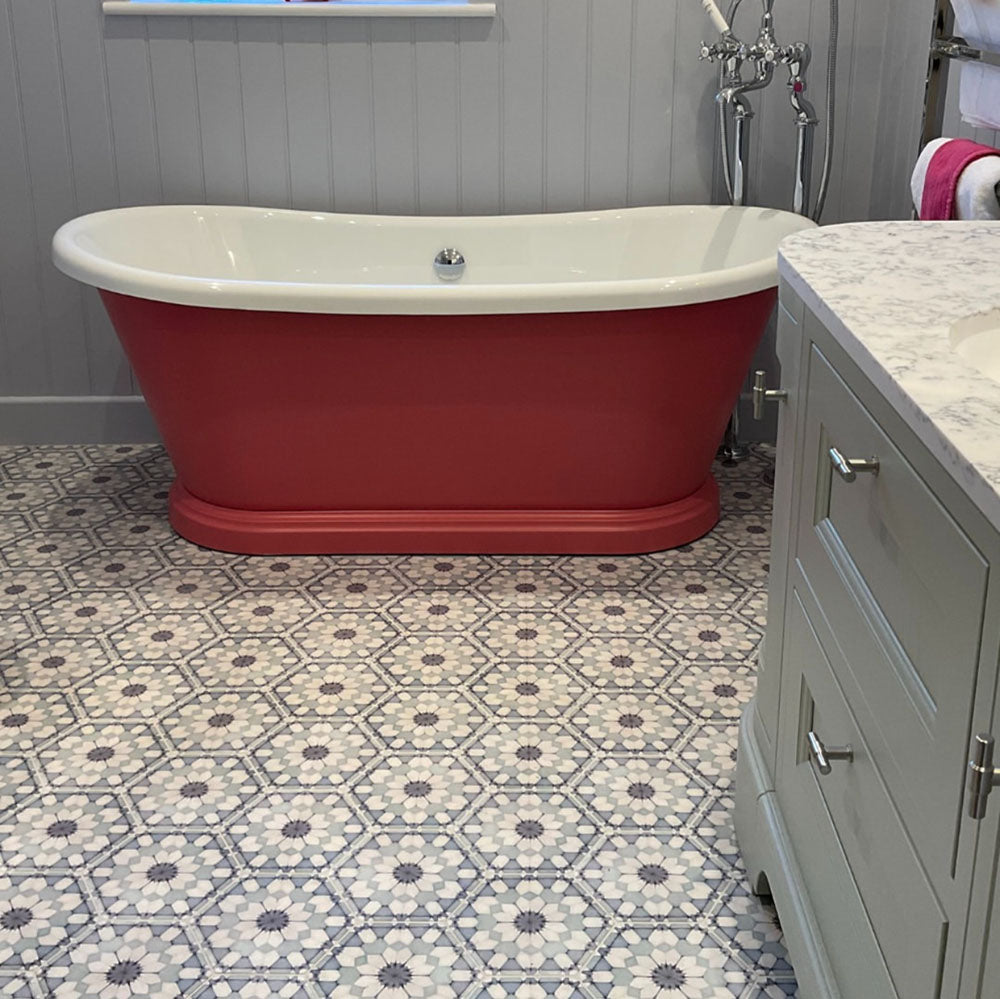 Badezimmer mit Medina Frostblau Feinsteinzeug-Hexagonfliesen im marokkanischen Stil im Format 18,7 × 21,6 cm, verlegt in einem sich wiederholenden geometrischen Muster und kombiniert mit einer freistehenden Badewanne sowie klassischer Badmöblierung.