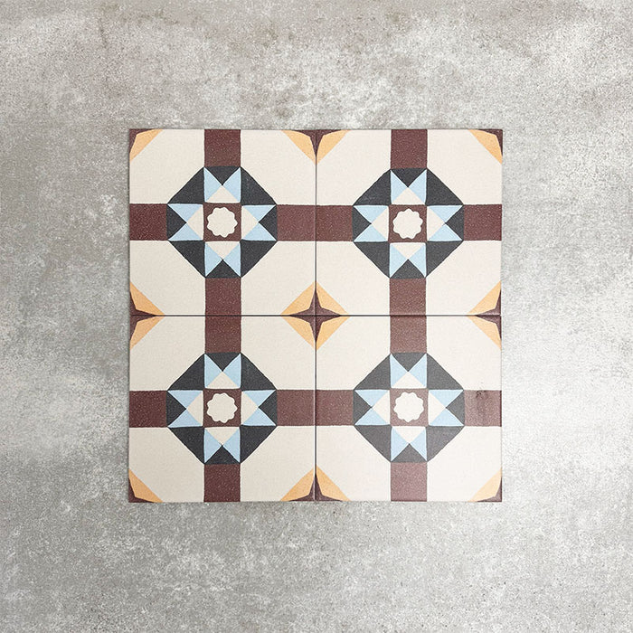 Vier Berlin Kreuz Feinsteinzeugfliesen im Format 20 × 20 cm im viktorianisch-marokkanisch inspirierten Stil, gemeinsam arrangiert zur Darstellung des wiederkehrenden geometrischen Sternmusters in Burgunder-, sanften Blau- und Cremetönen, inspiriert von klassischen dekorativen Bodenfliesen.