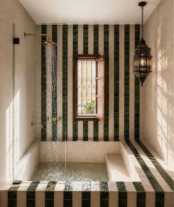 Badezimmer im marokkanischen Stil mit Bora Bora Quadrat Weißer Sand Wandfliesen im Format 10 × 10 cm, kombiniert mit dunkelgrünen quadratischen Fliesen in einem Streifendesign rund um eine eingelassene Badewanne und den Duschbereich.