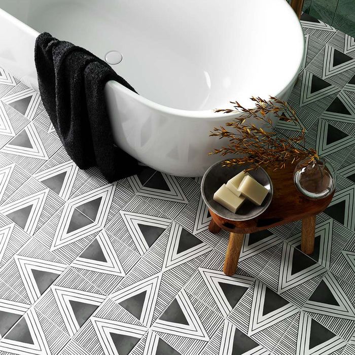 Badezimmer mit Almeira Giza Fliesen im marokkanischen Stil im Format 20 × 20 cm für Wand und Boden, gestaltet mit einem ausdrucksstarken schwarz-weißen Musterboden. Kombiniert mit einer freistehenden Badewanne und natürlichen Holzaccessoires für eine ausgewogene, stilvolle Atmosphäre.