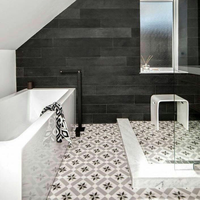 Badezimmer mit Canterbury Stern Bodenfliesen im viktorianischen Stil im Format 20 × 20 cm, verlegt als klassischer Musterboden. Ergänzt durch dunkle Wandfliesen in Steinoptik, eine freistehende Badewanne und eine moderne bodengleiche Dusche.