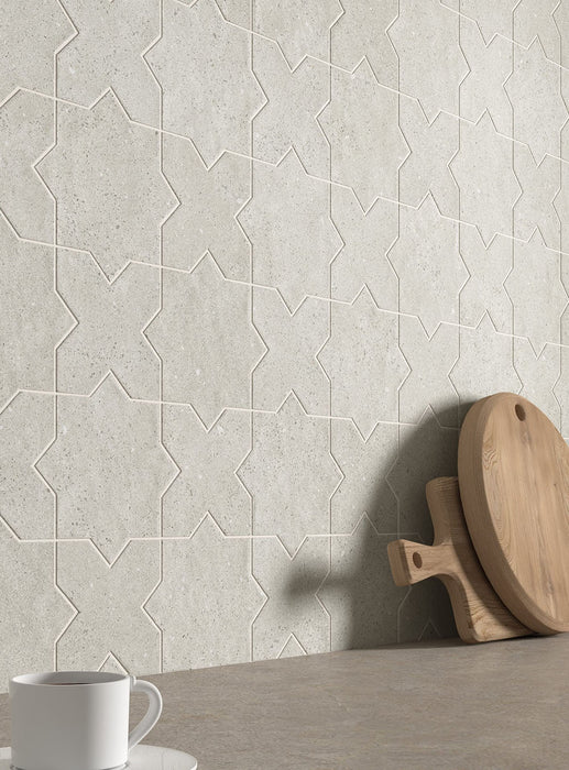 Moderne Küche mit Dohar Avorio Rocks Star & Cross Wand- und Bodenfliesen, die einen dekorativen geometrischen Fliesenspiegel in dezenten, von Naturstein inspirierten Farbtönen schaffen. Kombiniert mit grauen Arbeitsplatten, weißen Küchenfronten und modernen Geräten entsteht ein stilvolles und harmonisches Interior.