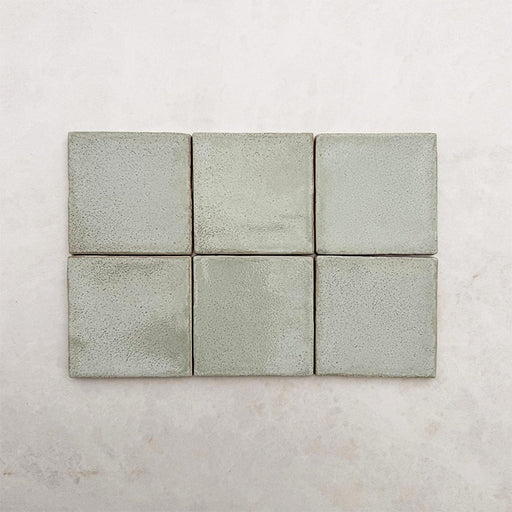 Dordogne Matcha Green Rustic Gloss Wandfliesen im Format 10 × 10 cm in sanften Grüntönen mit dezenten Farbvariationen und rustikaler Glanzoberfläche, die den handwerklich inspirierten Charakter und die leicht strukturierte Oberfläche der Kollektion hervorheben.