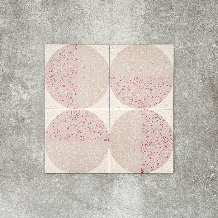 Detailní záběr dekorativních dlaždic Eclipse Rosa v terrazzo vzhledu ve formátu 20 × 20 cm v jemných odstínech blush a krémové, s geometrickými kruhovými vzory a tečkovanými detaily, doplněných růžovými květinovými akcenty.