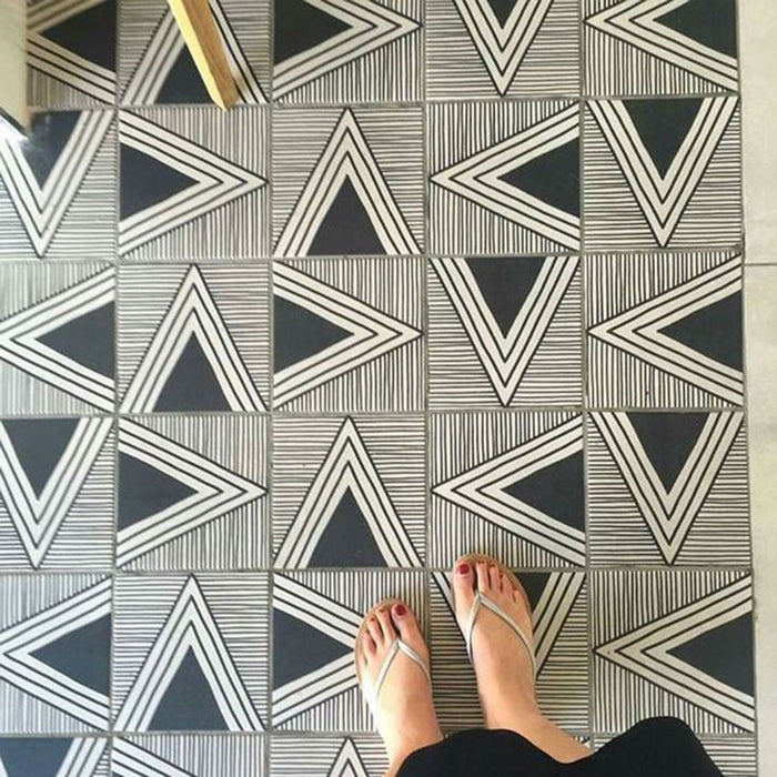 Bodenfläche mit Almeira Giza Feinsteinzeugfliesen im marokkanischen Stil in einem kräftigen geometrischen Dreiecksmuster in Schwarz und Weiß, Format 20 × 20 cm, für eine moderne und ausdrucksstarke Optik.
