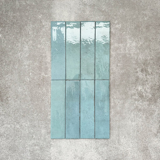 Nomadin Aqua Ziegel-Wandfliesen im Format 6 × 24,6 cm, vertikal verlegt, mit glänzender, leicht strukturierter Oberfläche und sanften Blau-Grün-Tönen für eine Optik im Industrial-Stil.