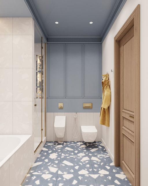 Badezimmer mit Melodie Rock Terrazzo Blau 60 × 60 cm Feinsteinzeug-Bodenfliesen mit sanft blauer Basis und großen weißen Zuschlägen, kombiniert mit Wandpaneelen, Messingarmaturen und hellen Holzelementen für ein frisches, modernes Gesamtbild.