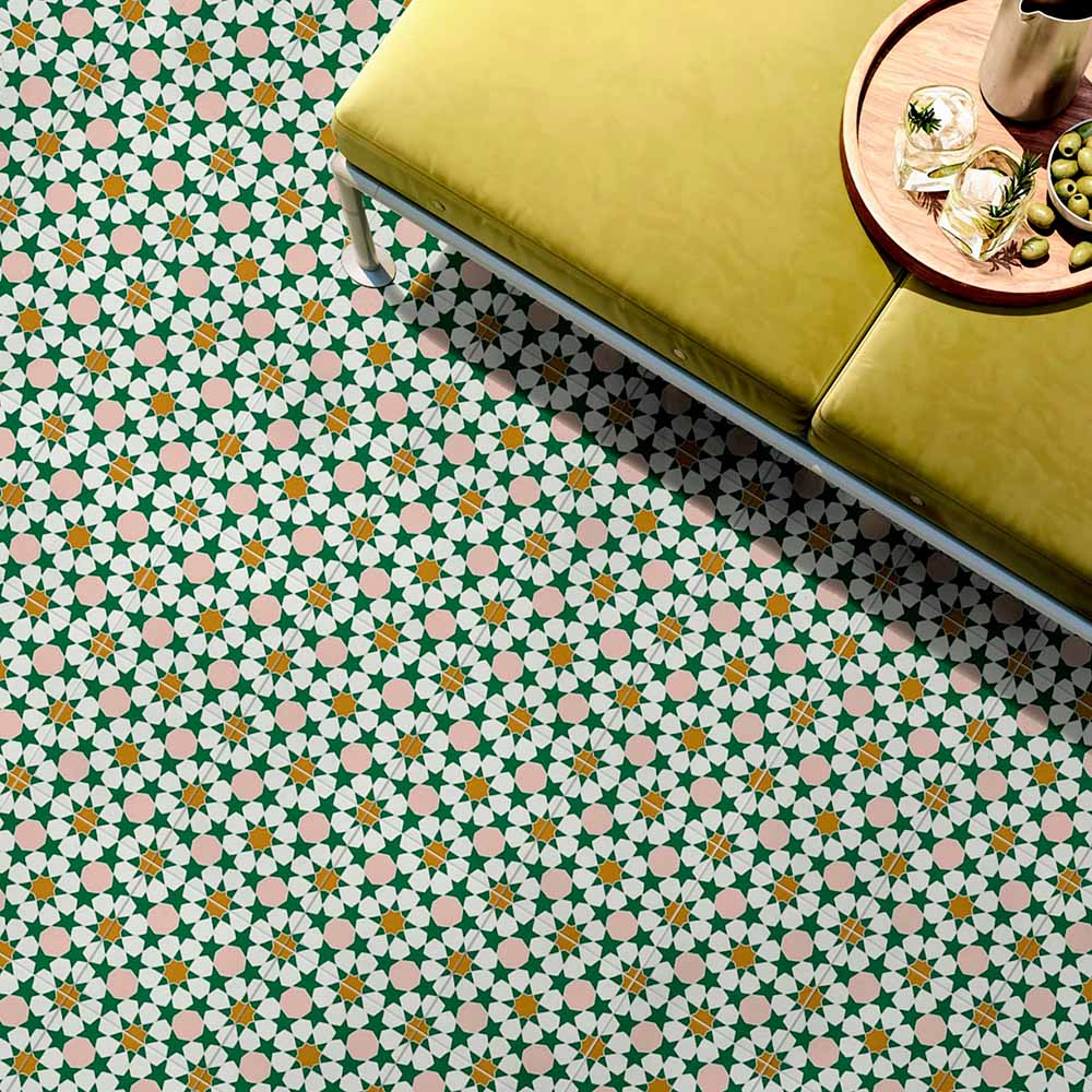 Innenboden mit Kuba Tanane Feinsteinzeugfliesen im marokkanischen Stil im Format 20 × 20 cm, verlegt in einem sich wiederholenden Stern- und Geometriemuster in Grün-, Weiß-, zarten Rosé- und warmen Gelbtönen. Kombiniert mit einer senffarben gepolsterten Bank und Accessoires, um das filigrane Design und die lebendige Farbpalette wirkungsvoll hervorzuheben.