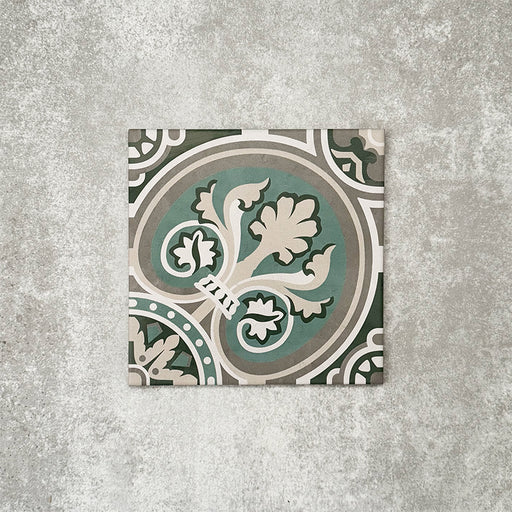 Einzelne Berlin Mitte Feinsteinzeugfliese im Format 20 × 20 cm im viktorianisch-marokkanisch inspirierten Stil in einer Produktszene. Zu sehen ist ein dekoratives, floral inspiriertes geometrisches Muster in Grün-, Salbei- und Cremetönen, angelehnt an traditionelle Bodenfliesen im viktorianischen Stil.