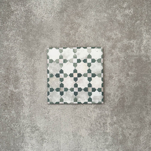 Einzelne Berber Mequinez Grün Feinsteinzeugfliese im marokkanischen Stil im Format 15 × 15 cm mit einem sanften geometrischen Muster in Grün und Creme, dargestellt auf neutralem Hintergrund.