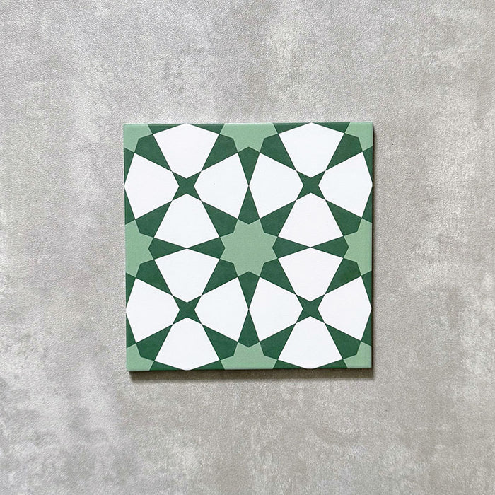 Einzelne Agadir Grün Fliese im marokkanischen Stil im Format 20 × 20 cm aus Feinsteinzeug mit einem geometrischen Sternmuster in sanftem Grün und Weiß, dargestellt auf neutralem Hintergrund.