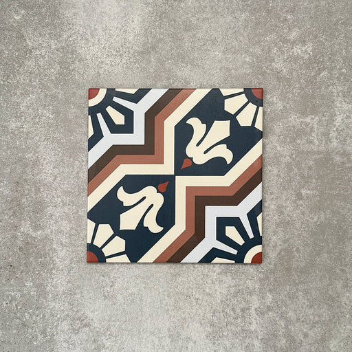 Einzelne Berlin Großartig Feinsteinzeugfliese im Format 20 × 20 cm im marokkanisch inspirierten Stil vor einem neutralen Hintergrund in Steinoptik. Gezeigt wird ein detailreiches geometrisches Muster in tiefem Blau, warmem Braun und sanften Cremetönen mit traditionell inspiriertem Design und klarer matter Oberfläche.
