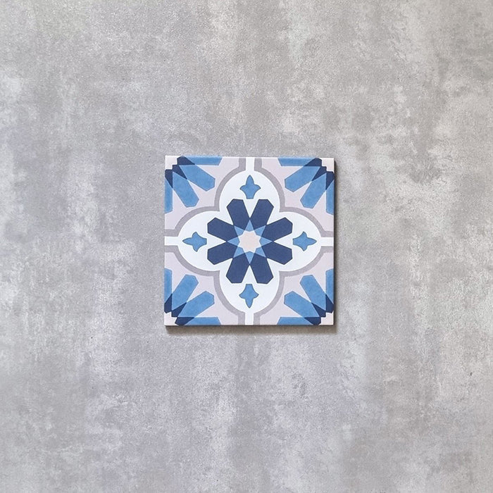Einzelne Clara Saphir Fliese im marokkanischen Stil im Format 20 × 20 cm, dargestellt auf neutralem Hintergrund. Das geometrische Muster in sanften Blau- und Weißtönen mit Sternmotiven hebt die dekorative Gestaltung und die feinen Farbdetails hervor.