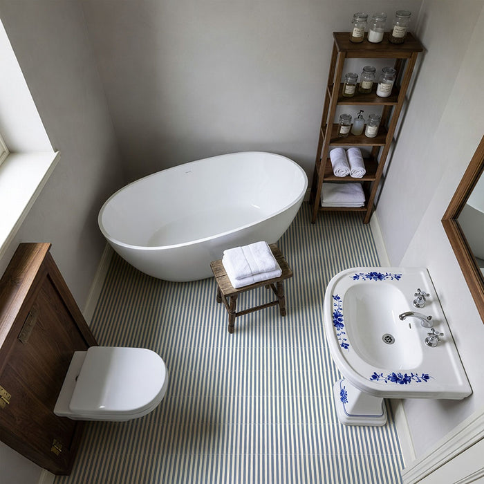 Badezimmer mit Skinny Pinstripes Blue Bodenfliesen im Moroccan Style im Format 20 × 20 cm, die ein markantes Streifendesign auf dem Boden schaffen. Kombiniert mit einer freistehenden Badewanne, einem klassischen Waschbecken und warmen Holzmöbeln entsteht ein zeitloses Interior voller Charakter.