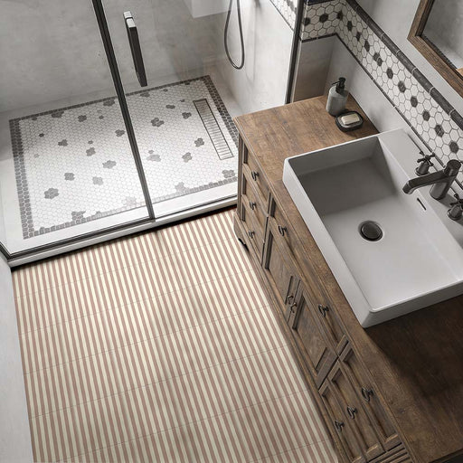 Badezimmer mit Skinny Pinstripes Rose Bodenfliesen im Moroccan Style im Format 20 × 20 cm, die ein sanftes Streifendesign auf dem Boden schaffen. Kombiniert mit einem rustikalen Waschtischunterschrank aus Holz, monochromen Mosaikfliesen im Duschbereich und Armaturen in gebürsteter Metalloptik entsteht ein zeitloses Badezimmerdesign.