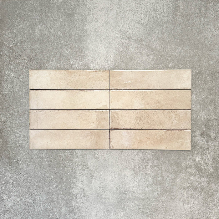 Nomadin Brick Creme Wandfliesen im Format 6 × 24,6 cm, gemeinsam verlegt, um den warmen, neutralen Farbton, die glänzende Oberfläche und die feine Oberflächenvariation zu zeigen.