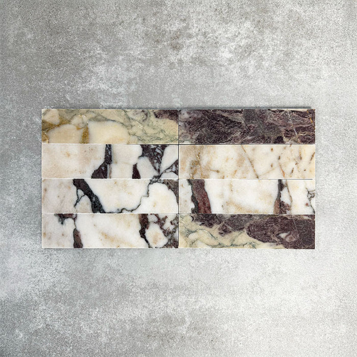 Fayrouz Viola 5 × 20 cm Naturmarmorfliesen mit geschliffener Oberfläche, mit weißer Basis und markanter bordeauxroter sowie warmtoniger Maserung, im sauberen Raster verlegt, um natürliche Variation und die charakteristische Steinstruktur hervorzuheben.